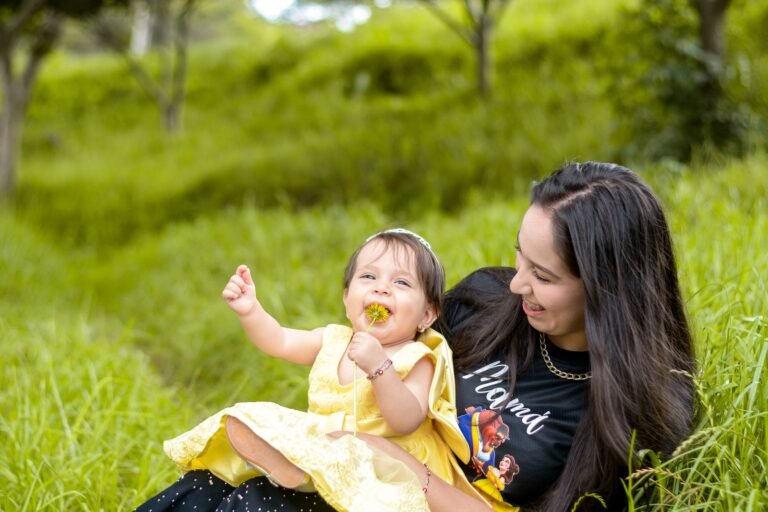Madre ecuatoriana con su hija pequena sentadas en un prado verde